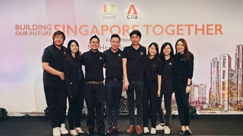 Crystal stands with seven of her team members on stage at a Channel News Asia event.